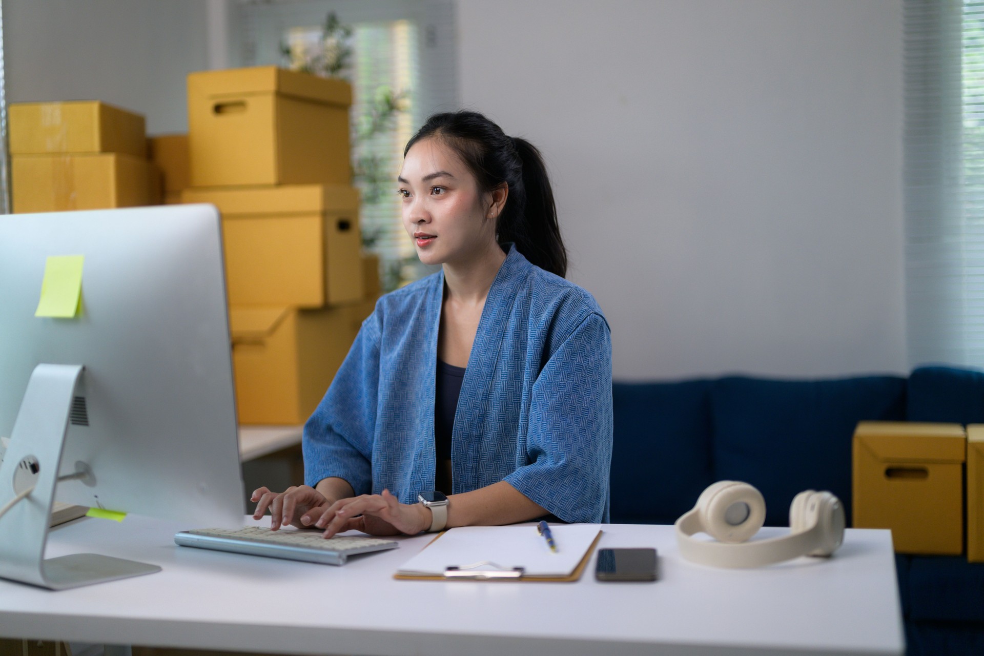 Young Asian businesswoman working at home using computer, managing her online store, startup, SME entrepreneur